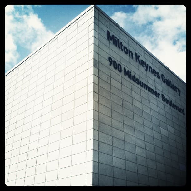 Corner of a pale block-clad building lettered Milton Keynes Gallery, 900 Midsummer Boulevard